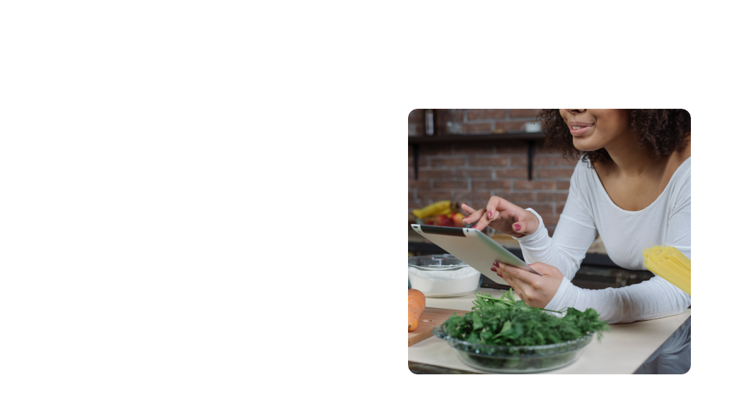 Pessoa utilizando tablet, cercada por ingredientes frescos