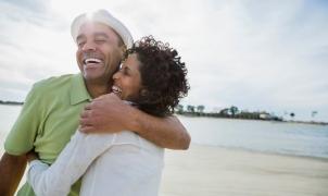 Um homem e uma mulher abraçam-se e sorriem.