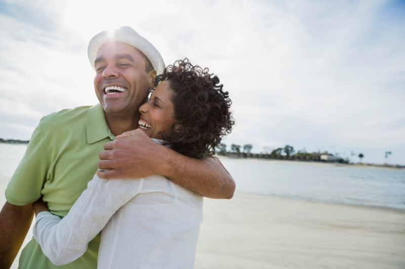 Um homem e uma mulher abraçam-se e sorriem.