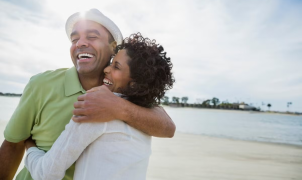 Um homem e uma mulher abraçam-se e sorriem.